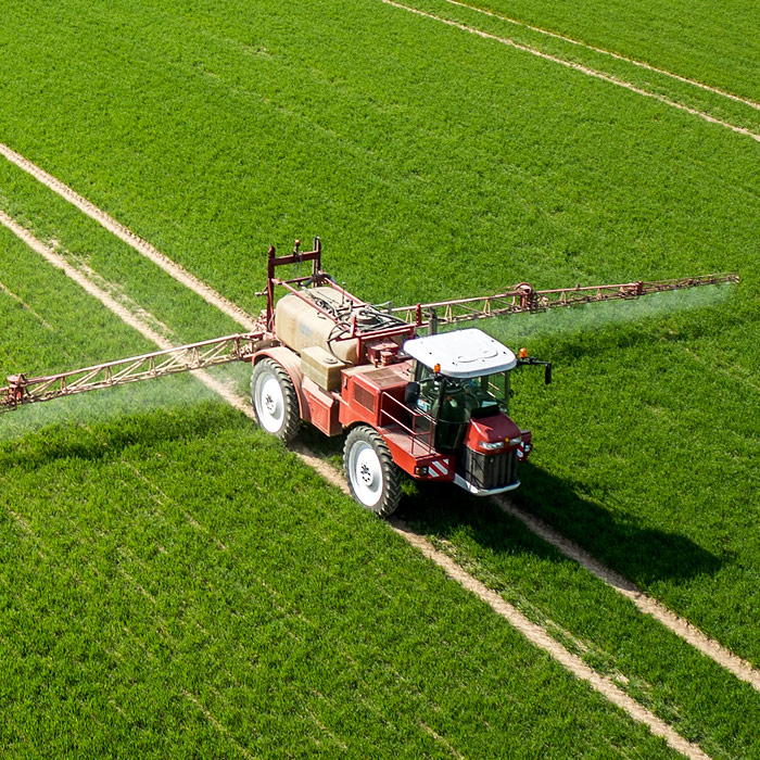 Farmer in tractor spraying crops